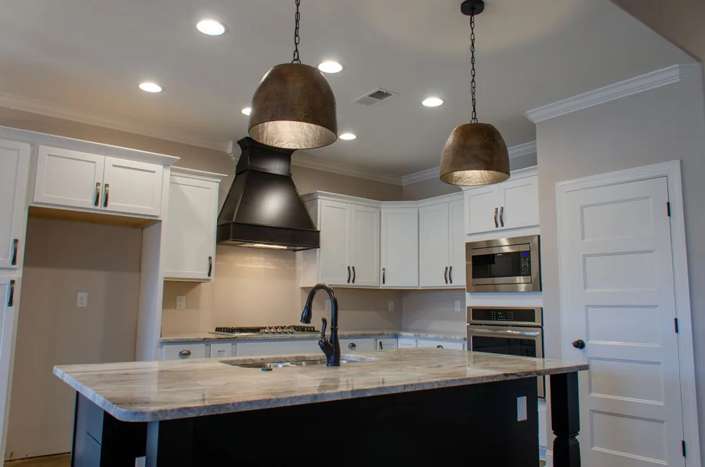 Kitchen with pendant lights and a black island