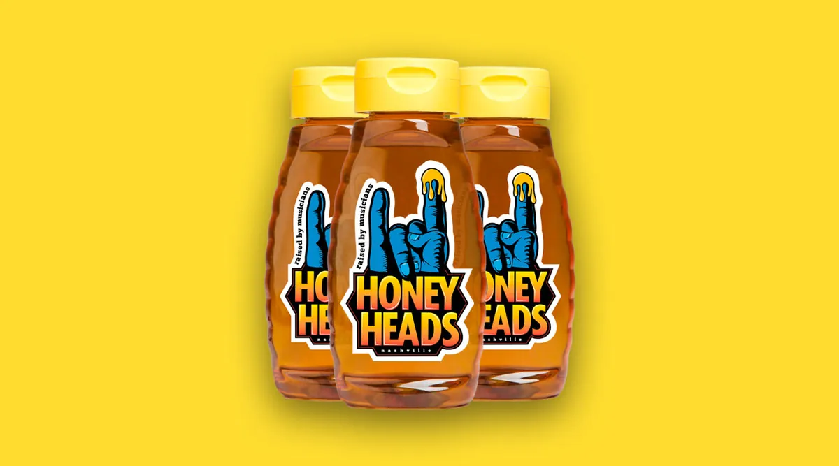 Three Honey Heads honey bottles with the new label on a yellow background