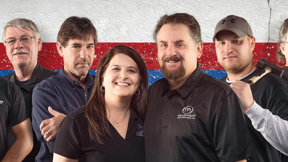 Millennium Paint & Body team portrait in front of a red, white and blue wall